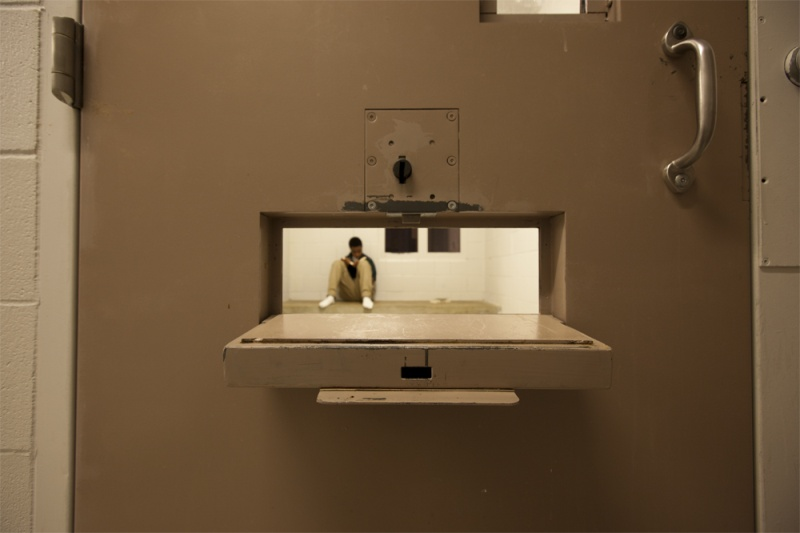 Juvenile reads. Shown through slot in the cell door.