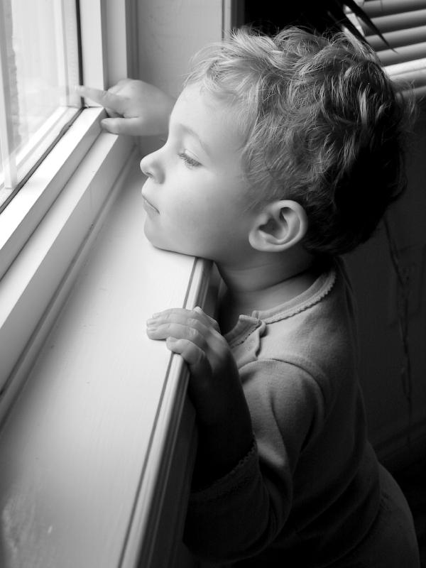 Little boy at window, pointing outside.