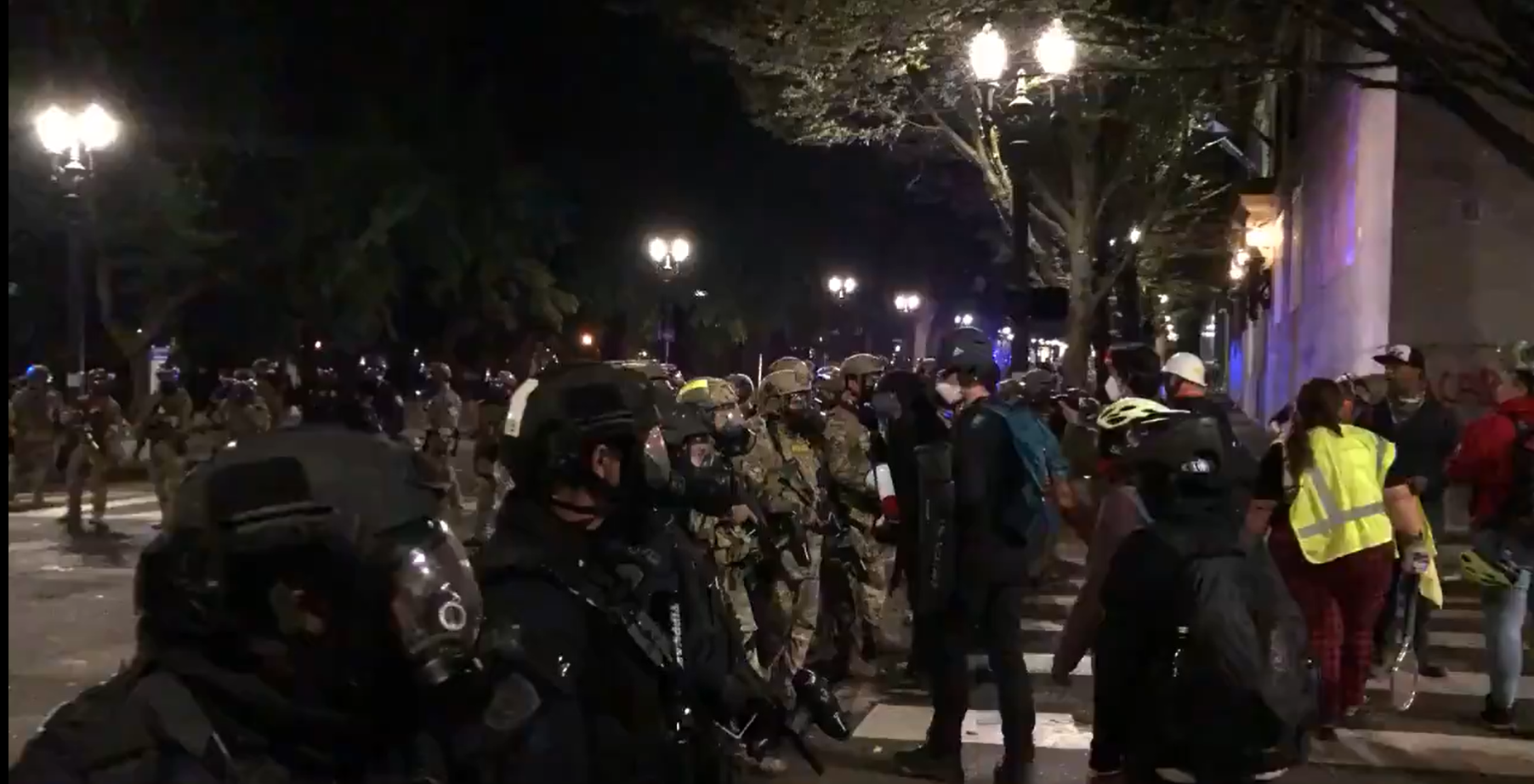 Federal officers in gas masks and camo, in Portland, with protestors