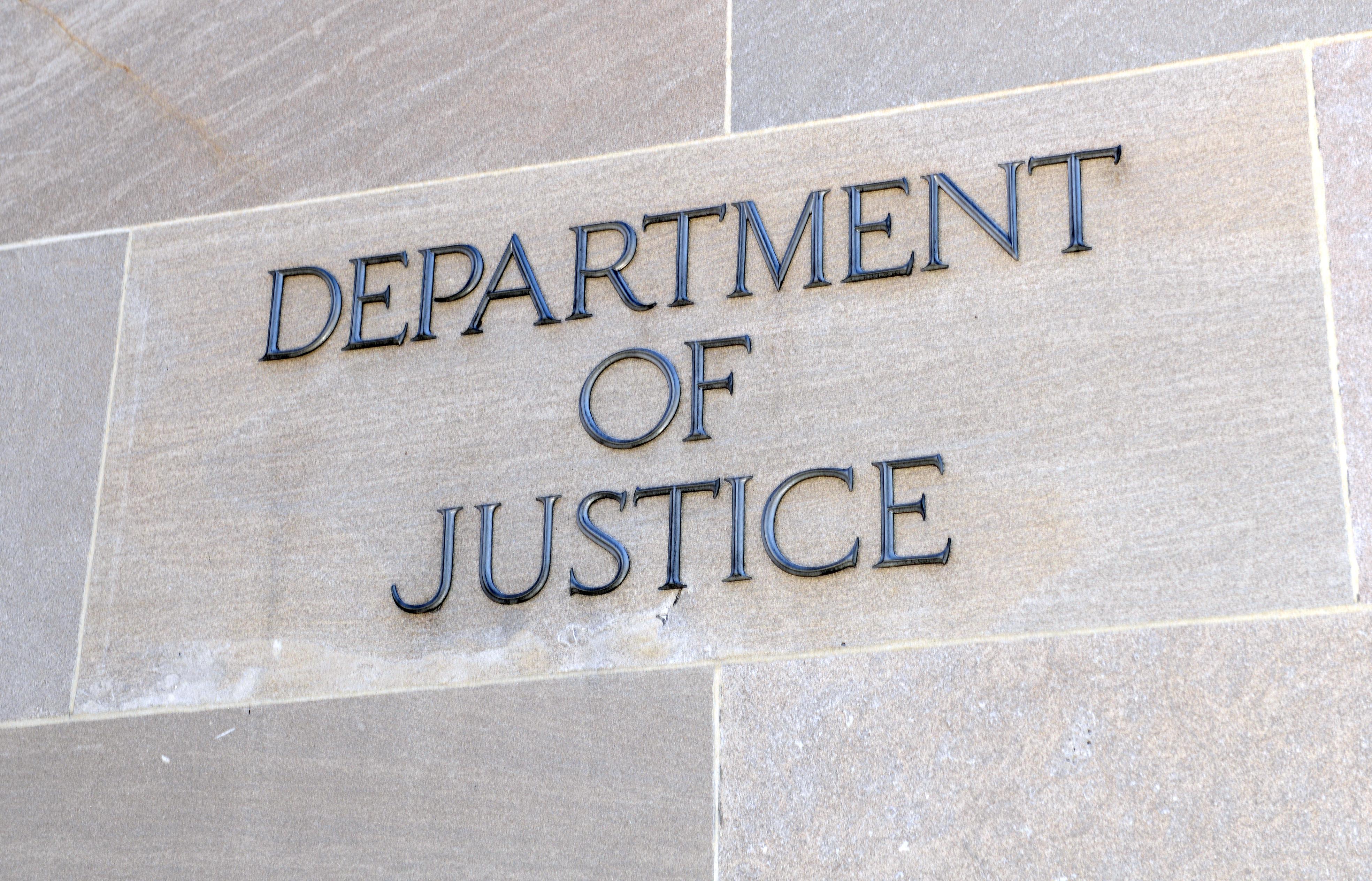 The Department of Justice sign on a wall of a building in Washington DC, USA.