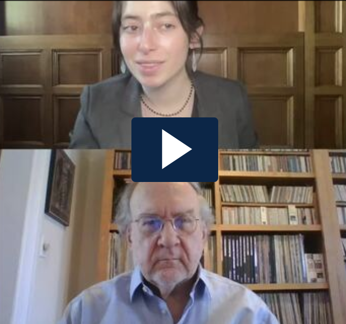 Screenshot of video interview, with Liz Lewis on top and John Boston on bottom of screen, and a white arrow in a black box in between them.